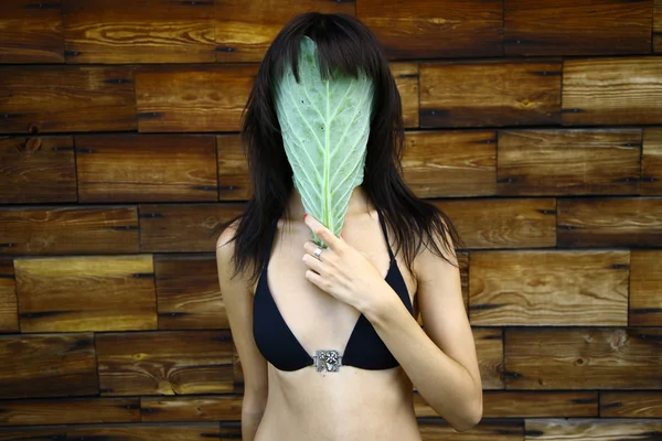 Молодая женщина в маске из листьев капусты — стоковое фото