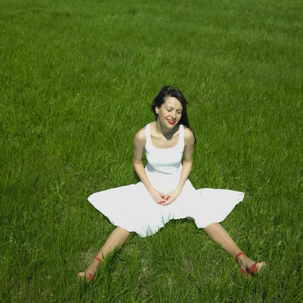 Fröhliche junge Frau auf der grünen Wiese — Stockfoto