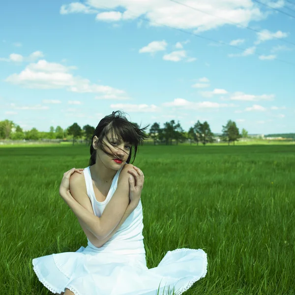 Hermosa joven en un campo verde — Foto de Stock