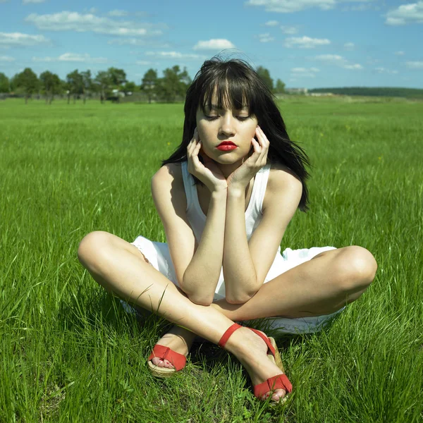 Beautiful young woman on a green field — Stock Photo, Image