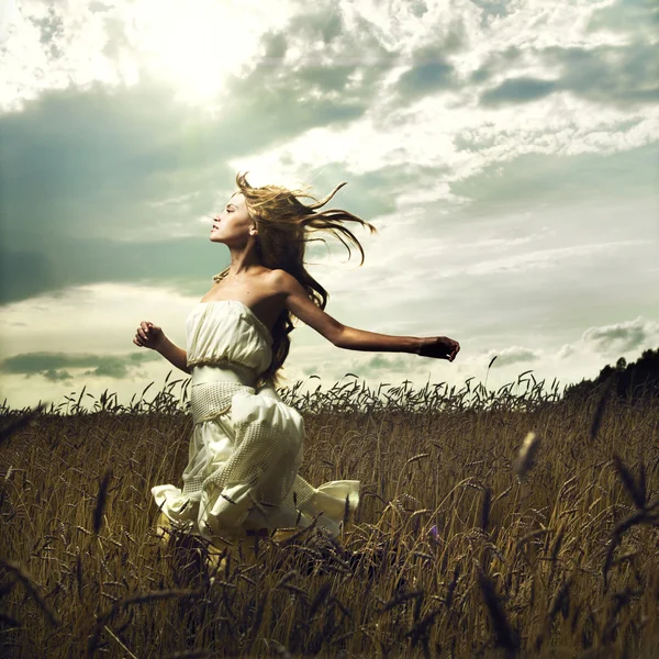 Chica corriendo a través del campo — Foto de Stock