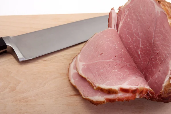 Ham on a board with knife — Stock Photo, Image