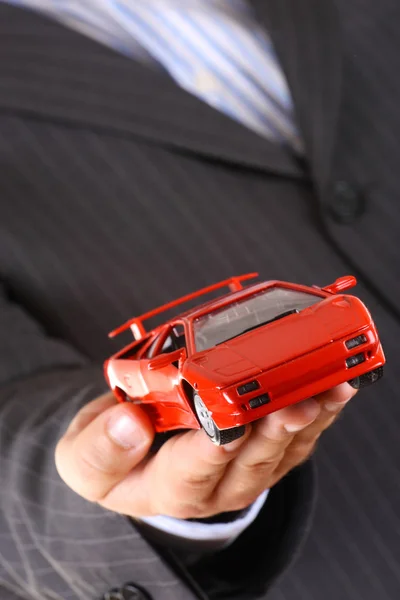 Businessman handing over a red sport car — Stock Photo, Image