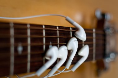 oordopjes als vingers op gitaar