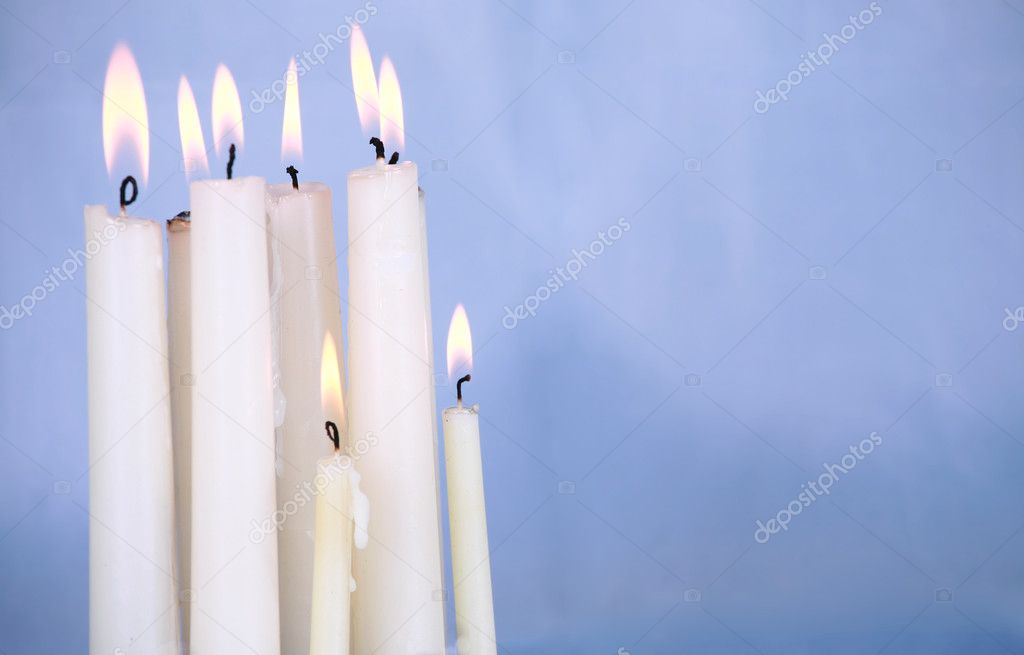 Candles burning against blue background