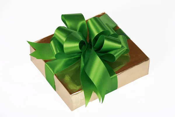 Gold present wrapped with green ribbons — Stock Photo, Image