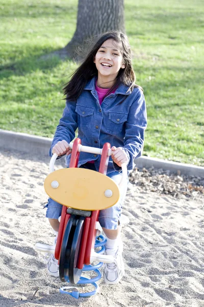 Menina jogando no parque infantil balançando cavalo — Fotografia de Stock