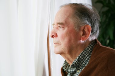 Elderly man looking out window clipart