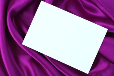 Blank white card on purple satin clipart