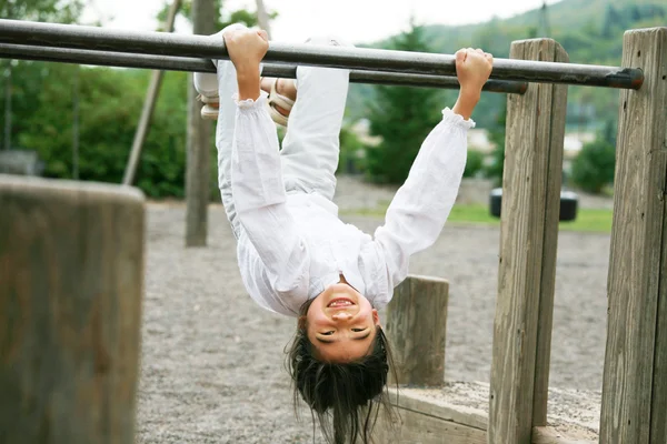 Little girl upside down at playground — Stock Photo, Image