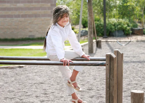 Kleines Mädchen sitzt auf Stangen — Stockfoto