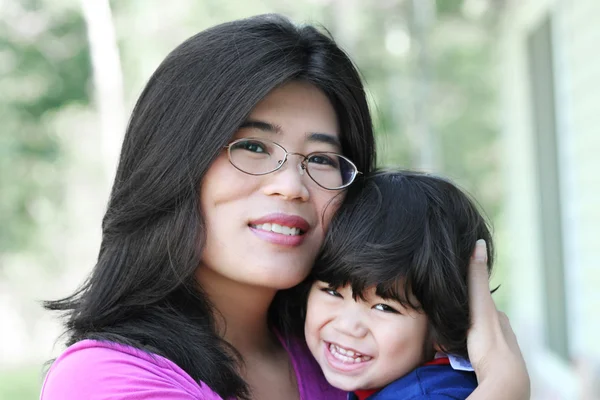 Asian mother lovingly holding her son — Stock Photo, Image