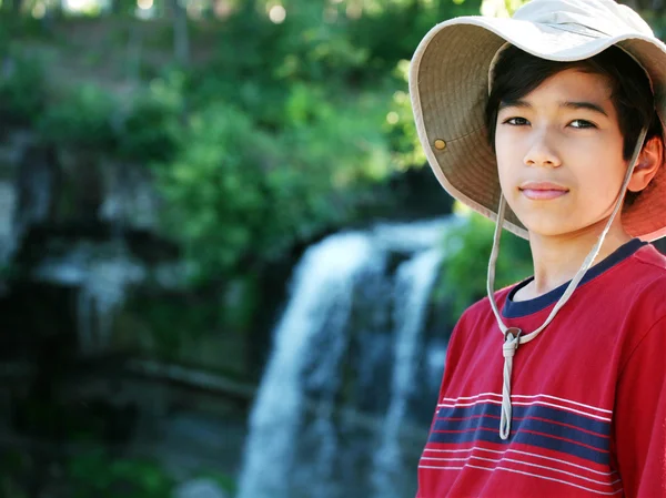 Young boy standing nect to water fall — Stock Photo, Image