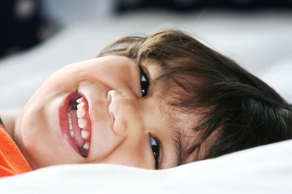 Happy little toddler boy lying down — Stock Photo, Image