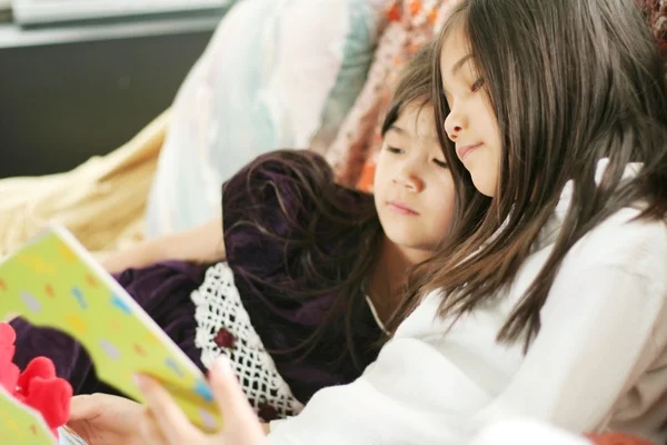 Две девушки читают книгу — стоковое фото