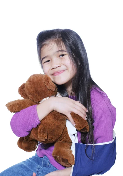 Mała dziewczynka ze złamaną ręką trzymająca lalkę — Zdjęcie stockowe