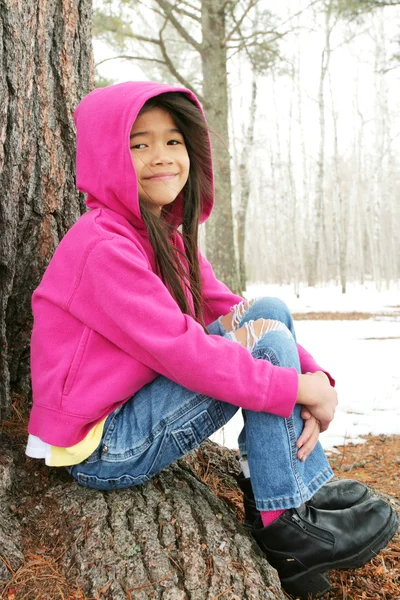 Παιδί κάθεται κάτω από δέντρο το χειμώνα — Φωτογραφία Αρχείου