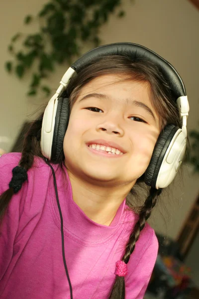 Six year old listening to music — Stockfoto