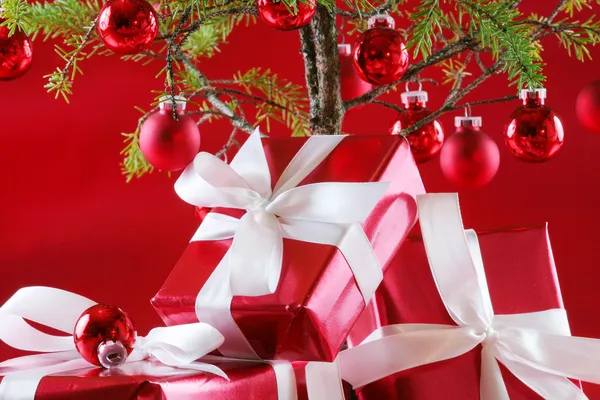 Elegant red presents under Christmas tree with d — Stock Photo, Image