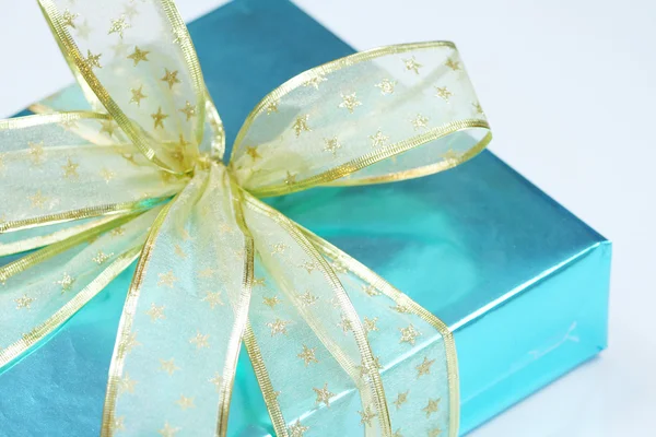 Élégant cadeau bleu enveloppé de rubans dorés — Photo