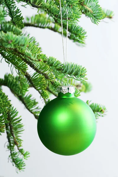 Green ornament hanging on Christmas tree. — Stock Photo, Image