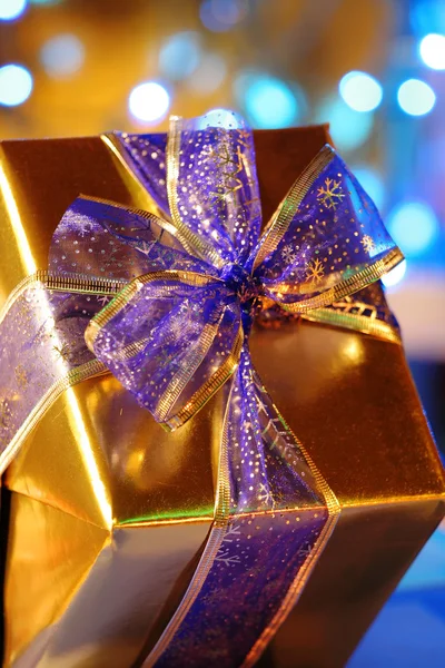 Elegant gold present with blue ribbons against b — Stock Photo, Image