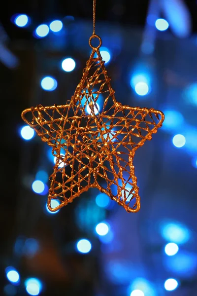 Gold star ornament with Christmas lights in back — Stock Photo, Image