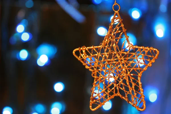 Adorno estrella de oro con luces de Navidad en la espalda —  Fotos de Stock