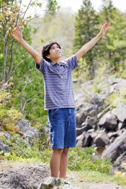 Teenage boy raising hands in praise clipart