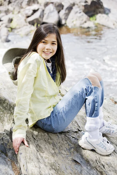 女孩坐在岩石峭壁边缘 — 图库照片