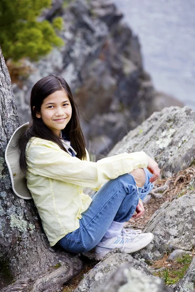 女孩坐在岩石峭壁边缘 — 图库照片