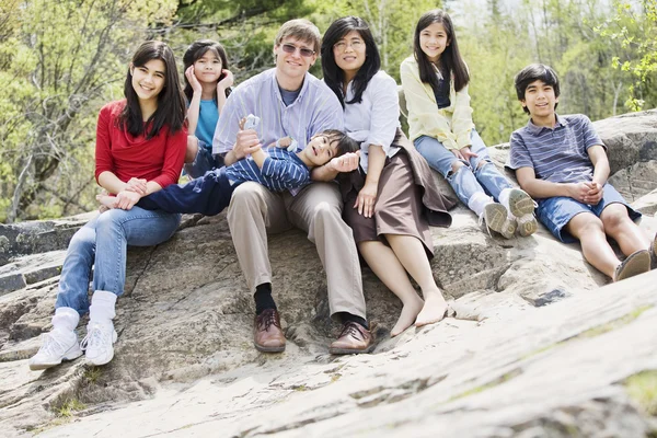Семья сидит вместе на скалистом выступе — стоковое фото