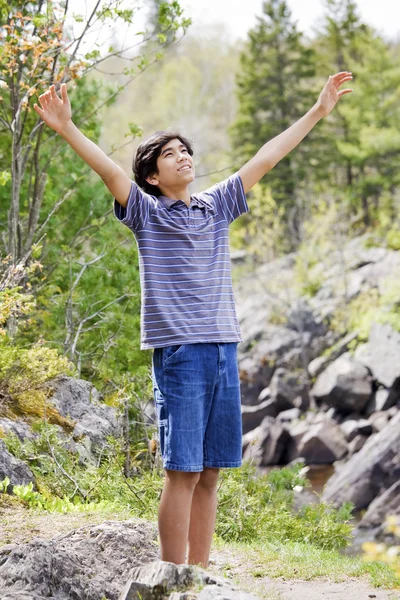 Мальчик-подросток, поднимающий руки в похвалу — стоковое фото