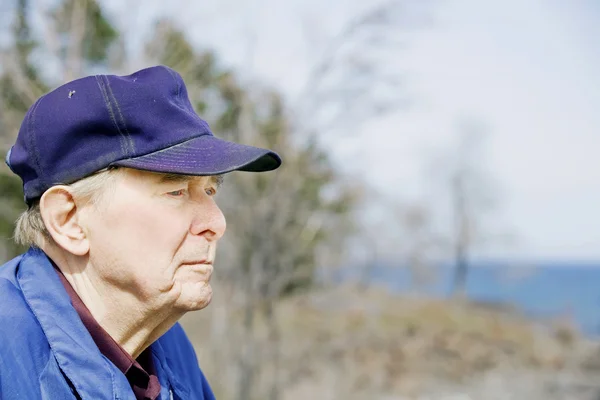 Пожилой человек смотрит на озеро — стоковое фото