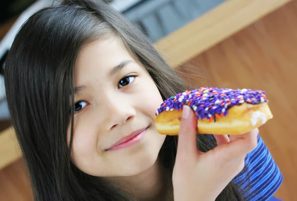 Girl holding colorful donut, ready to eat; — Stock Photo, Image
