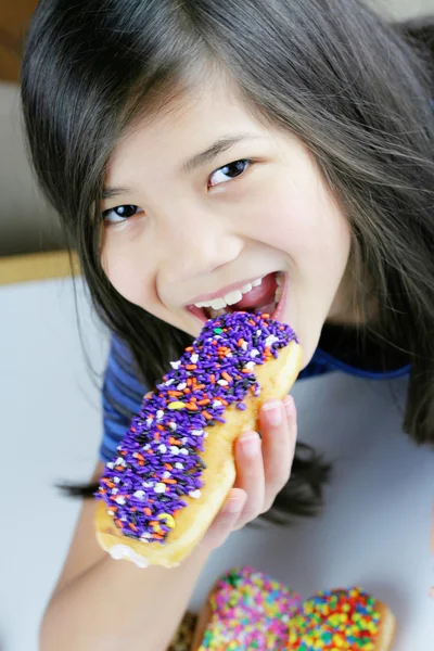 Girl holding colorful donut, ready to eat; — Stock Photo, Image