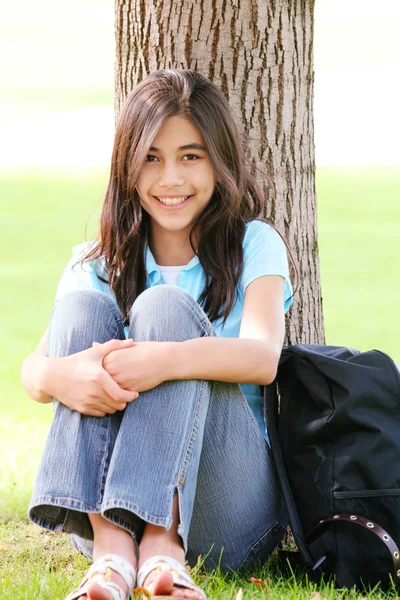 Joven adolescente chica sentado contra el árbol — Foto de Stock