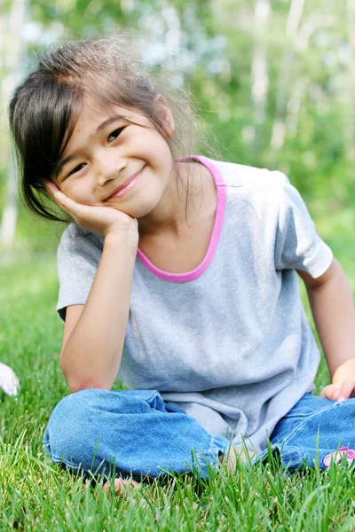 Kind sitzt auf Gras — Stockfoto
