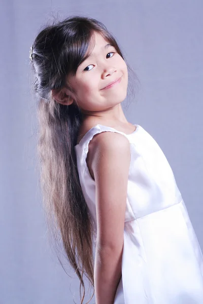 Красивая маленькая девочка в белом атласе — стоковое фото