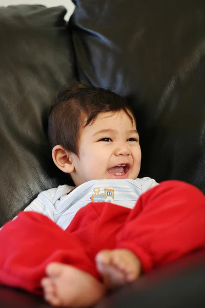 Счастливый ребенок, сидящий на диване — стоковое фото