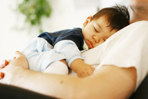 Baby slapen op Papa's borst Stockfoto