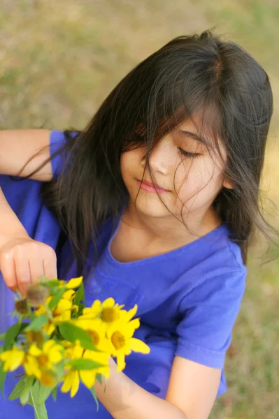 Kleines Mädchen mit einer Handvoll Sonnenblumen — Stockfoto