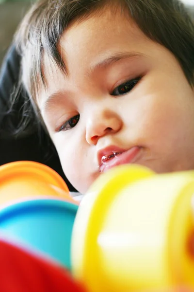 Младенец, играющий с цветными чашками — стоковое фото