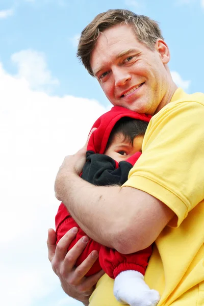 Baby cuddled safely in dad's arms — Stock Photo, Image