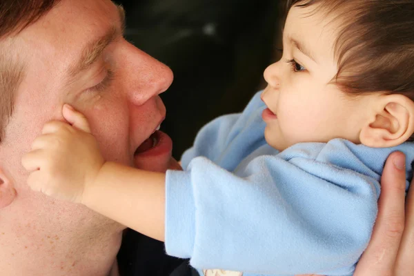 Baby teder aanraken papa's gezicht — Stockfoto