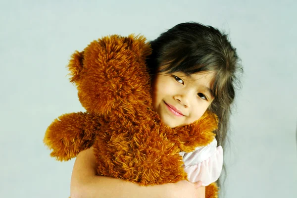 Criança abraçando seu ursinho de pelúcia — Fotografia de Stock