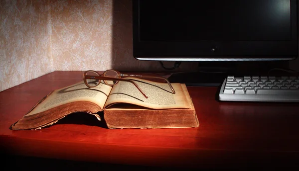 Vecchio libro, occhiali, monitor e tastiera — Foto Stock