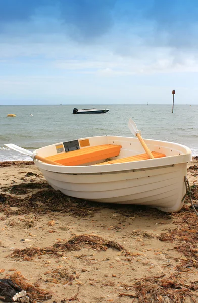 Бело-желтая лодка на берегу — стоковое фото
