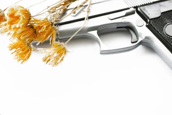 Pistola de mano y flores — Foto de Stock