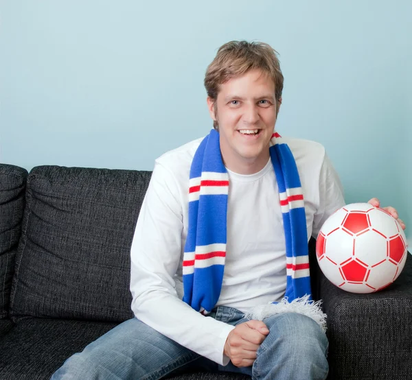 Lächelnder junger Mann beim Fußballgucken — Stockfoto